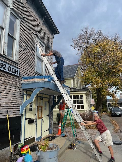 Volunteers working on the front exterior of the hall in 2022.